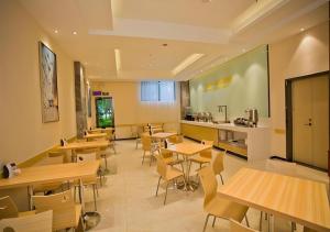 a restaurant with wooden tables and chairs and a kitchen at City Comfort Inn Deyang Wenmiao Square Gymnasium in Deyang