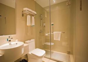 a bathroom with a shower and a toilet and a sink at City Comfort Inn Deyang Wenmiao Square Gymnasium in Deyang +27 photos