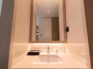 une salle de bain avec un lavabo et un miroir dans l'établissement City Comfort Inn Hefei Mingzhu Square Fanhua Avenue, à Hefei 149 autres photos