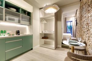 マラガにあるCoeo Frailes Design Apartmentsのキッチン(緑のキャビネット、テーブル付)