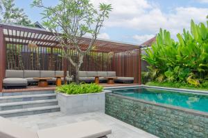 a swimming pool in a backyard with a wooden fence at Medewi Surf Villa Luxury in Airsatang