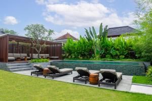 a backyard with a swimming pool and lounge chairs at Medewi Surf Villa Luxury in Airsatang