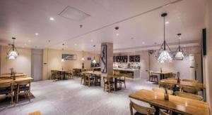 ein großes Zimmer mit Tischen und Stühlen in einem Restaurant in der Unterkunft City Comfort Inn Shaoguan High-speed Railway Station Xilian Examination Center in Shaoguan