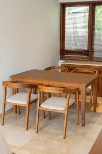 a wooden dining room table and chairs with a window at Medewi Surf Villa Luxury in Airsatang