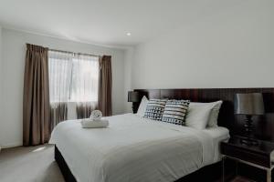 a bedroom with a large bed and a window at Urban 1-Bed Apartment in the Heart of the City in Canberra