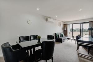 a living room with a dining room table and chairs at Urban 1-Bed Apartment in the Heart of the City in Canberra