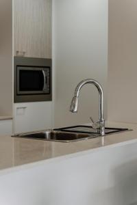 a kitchen counter with a sink and a microwave at Urban 1-Bed Apartment in the Heart of the City in Canberra +5 photos