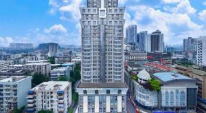 a tall building with a clock tower in a city at City Comfort Inn Liuzhou Wuxing Walking Street Zhonghuan Tower in Liuzhou