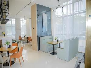 a dining room with tables and chairs in a room at City Comfort Inn Wanning Wan'An Avenue High Speed Railway Station in Wanning