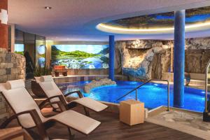 a room with a large aquarium with chairs and a table at BelArosa Suiten & Wellness in Arosa