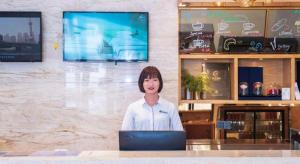a woman standing in front of a laptop computer at City Comfort Inn Zhongshan Banfu in Huancheng +202 photos