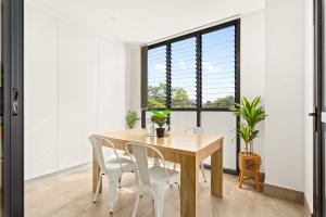 une salle à manger avec une table et des chaises en bois dans l'établissement Coastal 2-Bed Apartment near Beach, à Deewhy