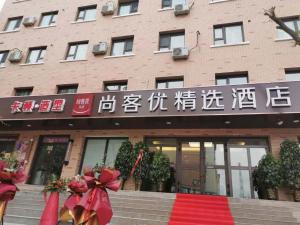 a building with a red ribbon in front of it at Thank Inn Plus Hotel Xinjiang Urumqi Tianshan District Bingtuan Erzhong in Ürümqi