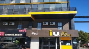 un hôtel avec une enseigne devant un bâtiment dans l'établissement IU Hotels Beijing Changping Bei Qijia, à Changping