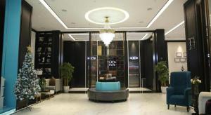 eine Lobby mit einem Weihnachtsbaum in der Mitte eines Gebäudes in der Unterkunft Xana Hotelle Nanchang Hongdu Middle Avenue Provincial TV Station in Nanchang County