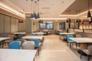 ein Esszimmer mit Tischen und blauen Stühlen in der Unterkunft Starway Hotel(Shuiximen Street,Nanjing) in Nanjing