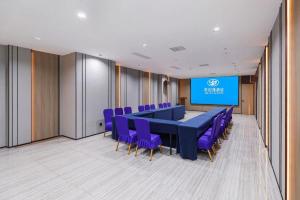 einen Konferenzraum mit einem langen Tisch und lila Stühlen in der Unterkunft Starway Hotel(Shuiximen Street,Nanjing) in Nanjing