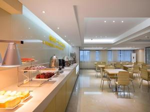 a cafeteria with a buffet line with tables and chairs at City Comfort Inn Hengyang Shigu Shuyuan in Hengyang
