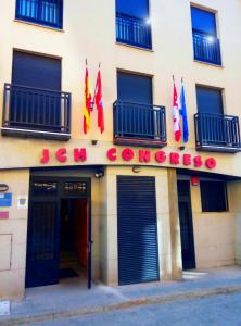 un edificio con banderas en la parte delantera en JCH Congreso Apartamentos, en Salamanca