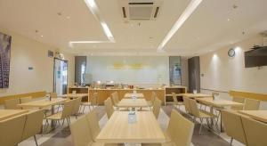 ein Restaurant mit Tischen und Stühlen in einem Raum in der Unterkunft City Comfort Inn Nanning Wuyi Road Department of Motor Vehicles in Nanning