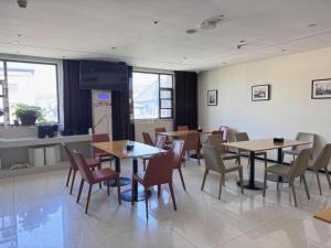 a restaurant with tables and chairs in a room at City Comfort Inn Shiyan Wudang Mountain in Danjiangkou