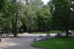 mensen op banken in een park met bomen bij Jaukus butas Klaipėdos centre in Klaipėda