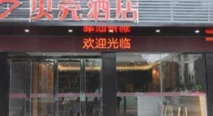a store with a sign on the front of it at Shell Hotel Kaifeng Jin'an Road Bianxihu Wanda Plaza in Kaifeng