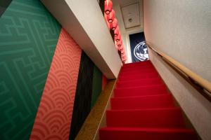 een trap in een gebouw met rode tapijtwanden bij The Kabuki-do Inn Haneda in Tokyo +84 foto's