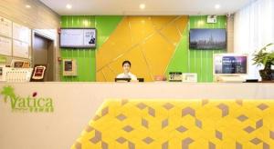 une femme assise au comptoir d'un magasin dans l'établissement Vatica Hotel Haikou Jinniuling Park Haizhiyuan, à Haikou