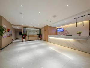 an empty lobby with a large room with a reception desk at Shell Hotel Anhui Huaibei Suixi County Economic Development Zone in Suixi