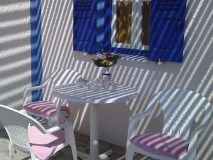 a table and two chairs and a table and a mirror at DARZENTA ATHINA APARTMENTS Perivolos in Perivolos
