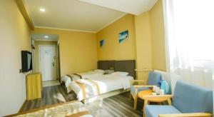 a hotel room with two beds and a television at GreenTree Alliance Hotel Qinghuangdao Wanda Plaza in Qinhuangdao +153 photos