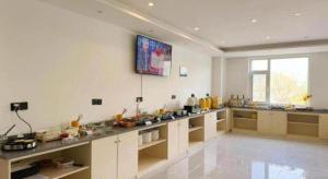 une grande cuisine blanche avec un grand comptoir dans l'établissement GEM Hotel Zibo Economic Development Zone Zibo Vocational Institute, à Jinan