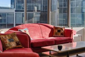 un salon avec un canapé rouge et une table dans l'établissement Canberra Lakefront 2-Bed with Pool, Gym & Parking, à Kingston  15 autres photos