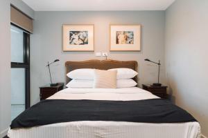 une chambre avec un grand lit avec des oreillers blancs dans l'établissement Stunning 1-Bed Above Foreshore with Water Views, à Kingston 