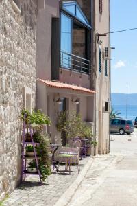 a patio with a table and chairs on the side of a building at Apartments Glusac in Podgora