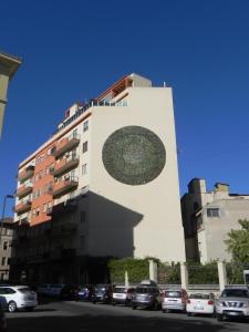 un edificio con un círculo pintado a un lado. en casaTati, en Cagliari