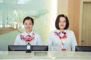 two people wearing ties standing in front of a table at Green Tree Inn Changzhou Liyang Zhongguancun Innovation Park in Liyang