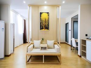 a living room with a white couch and a table at Green Tree Inn Changzhou Liyang Zhongguancun Innovation Park in Liyang