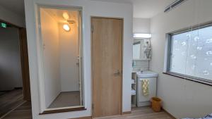 Un baño con inodoro, ventana y puerta. en Ippaku 一泊, en Izumisano