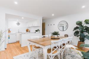 a kitchen and dining room with a wooden table and chairs at Lakeside 3-Bed Apartment with Jacuzzi in Belconnen