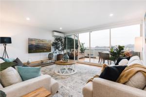 ein Wohnzimmer mit zwei Sofas und einem Tisch in der Unterkunft Lakeside 3-Bed Apartment with Jacuzzi in Belconnen