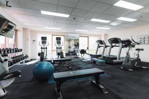 Un gimnasio con cintas de correr y máquinas en una habitación. en Center 1-Bed with Sauna, Gym, BBQ & Parking, en Canberra