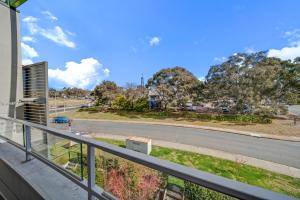 Un balcón con vista a una calle y árboles. en Tranquil Apartment in Green, Well Connected Suburb, en Lyons