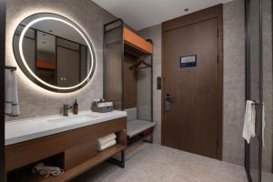 un bagno con lavandino e specchio di UrCove by Hyatt Xi'an Bell Tower Huimin Street Hotel a Xi'an