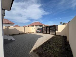 una entrada de una casa con una valla y un coche en TAF City Home, en Sifoe