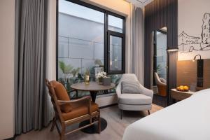 una camera d'albergo con un letto, un tavolo e una sedia di UrCove by Hyatt Xi'an Bell Tower Huimin Street Hotel a Xi'an