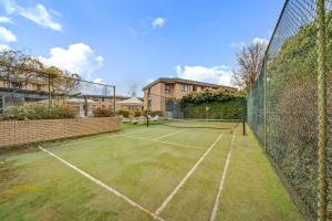 Una cancha de tenis con una red en la cancha en 2-Bed with Pool, BBQ, Tennis Court & Parking, en Kingston 
