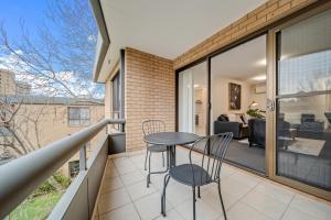 Un balcón con dos sillas y una mesa. en 2-Bed with Pool, BBQ, Tennis Court & Parking, en Kingston 