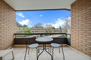 balcón con 2 mesas y sillas y ventana grande en 2-Bed with Pool, BBQ, Tennis Court & Parking, en Kingston  12 fotos más